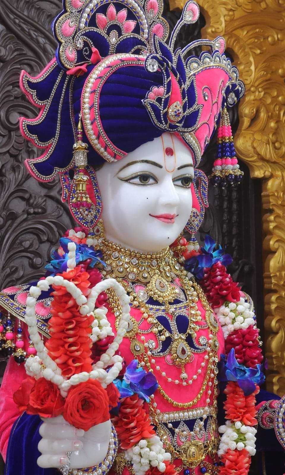 Swaminarayan with floral garland and crown.