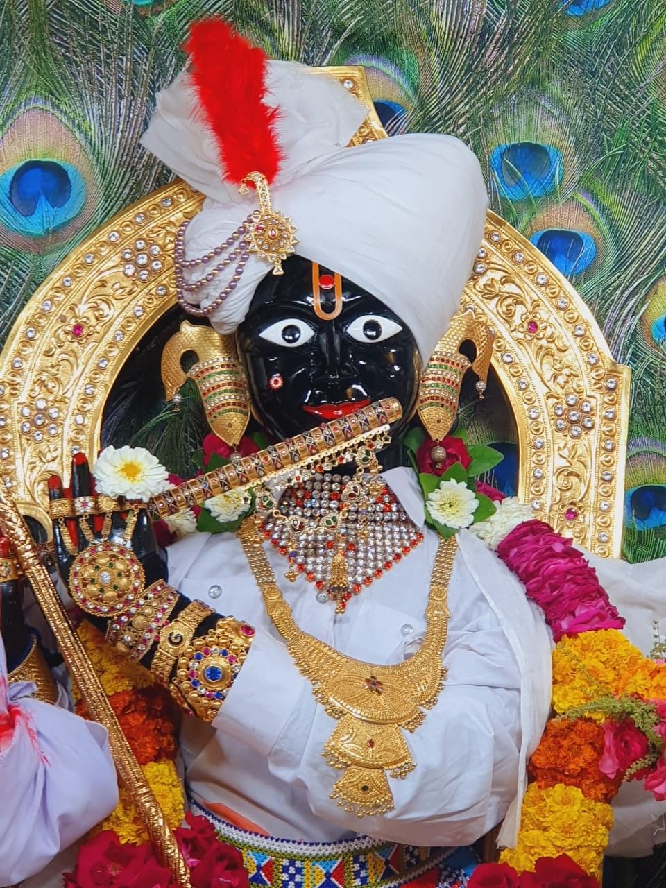 Swaminarayan with floral decorations and gold jewelry