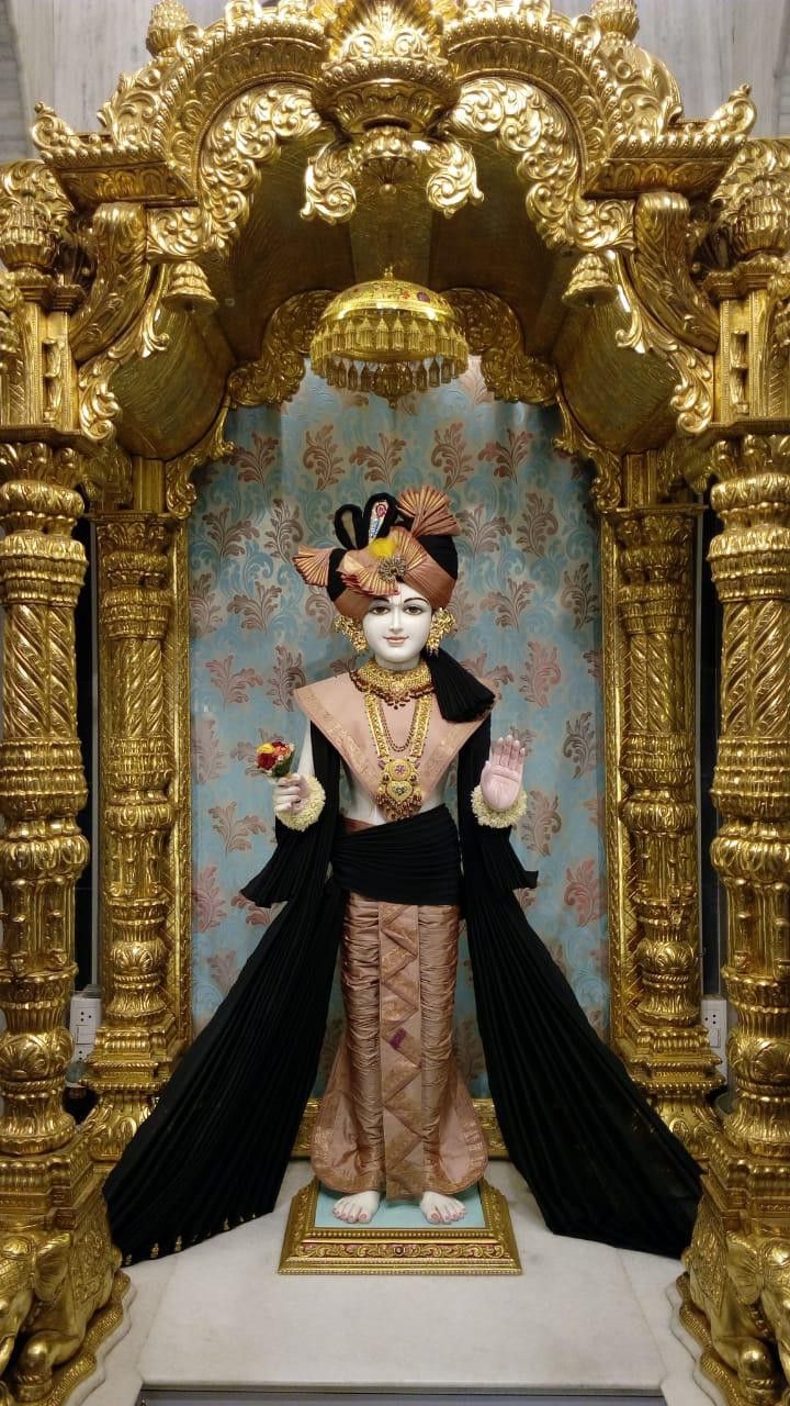 Swaminarayan in ornate temple setting.