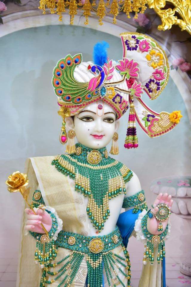 Adorned Swaminarayan idol with peacock feather.