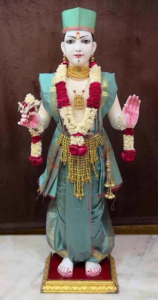 Swaminarayan statue with floral garland.