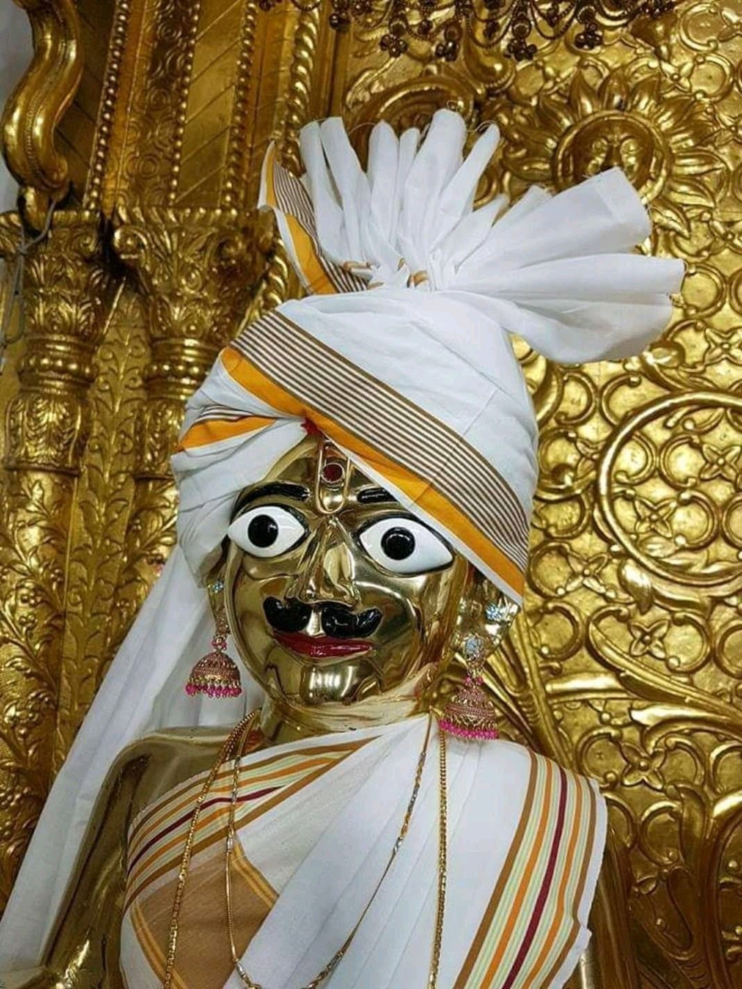 Golden Swaminarayan deity with ornate turban