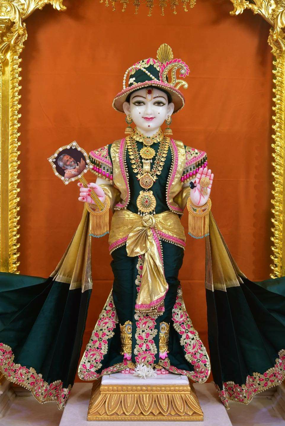 Swaminarayan murti adorned in gold attire
