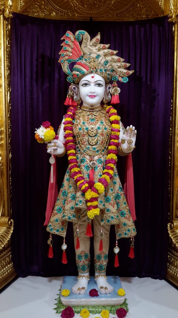 Swaminarayan statue with flowers and jewelry